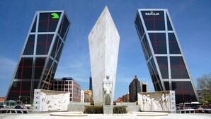 A plaza with a central monument, surrounded by modern buildings with glass facades and red accents. - Townhouse near Plaza Castilla - Apartment CUZCO (Madrid)
