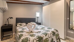 A bedroom with a bed, a nightstand, a lamp, a window, and a mirror. - Townhouse near Plaza Castilla - Apartment CUZCO (Madrid)