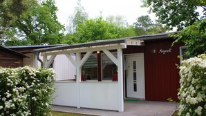 A small, single-story building with a covered porch and a door labeled "8". - Bungalow "Morgenrot", 250 m to the Müritz & jetty, alternative form of payment possible (Röbel/Müritz)