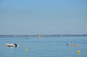 Una masa de agua tranquila con barcos y kayaks.