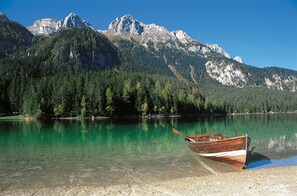 Un barco en un lago despejado con montañas al fondo.