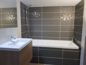 Bathtub, hair dryer, towels, toilet paper