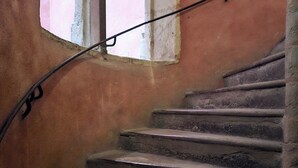 A staircase with stone steps and a metal handrail, leading to a window with a pink wall. - Studio Vieux Lyon  (Lyon)