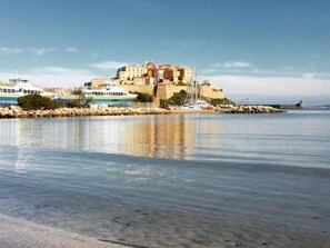 A coastal town with a prominent building, calm water, and boats. - Studio with terrace 200m Calvi beach (Calvi)