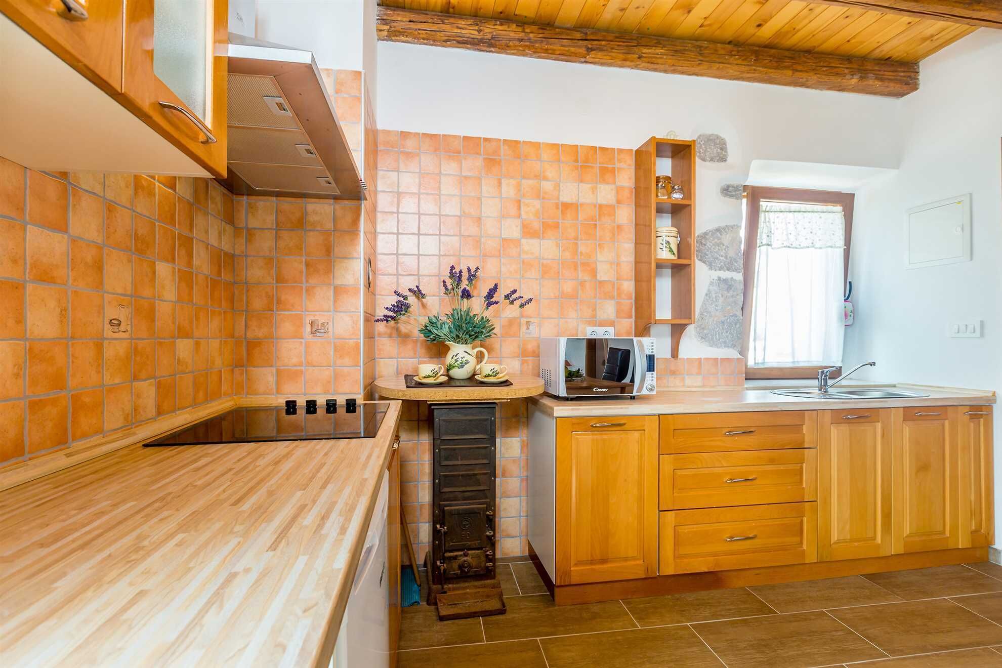 A kitchen with wooden cabinets, a built-in stove, and a microwave on the counter.