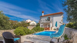 A villa with a swimming pool, outdoor furniture, and a stone wall. - Beautiful holiday house KORNIC (Kornić)