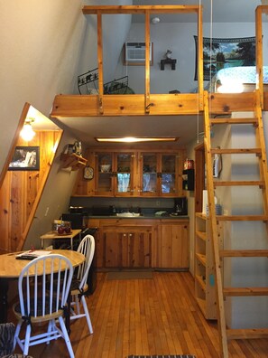Cozy retreat with a loft area, kitchenette, and dining space.