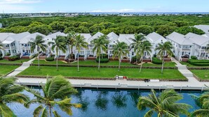 Un resort con varias edificaciones blancas, una piscina y palmeras.