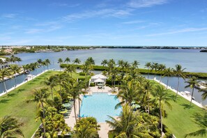 A resort with a swimming pool surrounded by palm trees and a view of the water. - Waterfront luxury Villa (14) with spectacular sunset views and boat slip (Marathon)