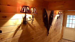 Un interior de madera con dos lámparas de pared y una puerta.