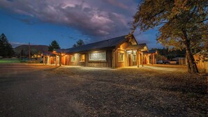 A rustic building with a sign reading "FORTRESS Home Builders" at dusk. - GNP Explorers Stay Here–2bd/1ba K/Q Bed-7mi To GNP (Coram)