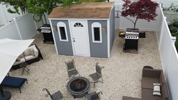 A backyard with a small shed, outdoor seating, and a grill area. - A Stone Throw to Beach and Convention Center and Two Blocks from the Crest!! (Wildwood)