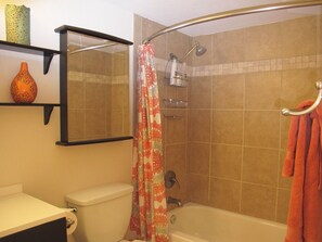 Ein Badezimmer mit Dusche, Toilette und Ablagefläche mit Dekoration.
