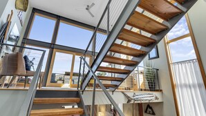 A modern interior with a staircase, large windows, and a ceiling fan. - UNBEATABLE LOCATION! Downtown Hood River Loft with Views, Pet Friendly (Hood River)