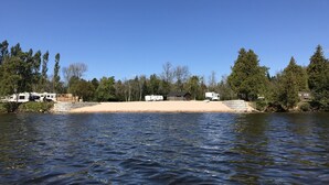 Ein See mit Wohnmobilen und Ferienhäusern am Ufer.