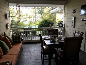 Un patio acogedor con una mesa de comedor lista para dos personas, rodeado por una barandilla blanca.