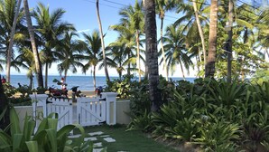 A pathway leading to a beach with palm trees and a view of the ocean. - Seaside Apartment (Las terrenas)