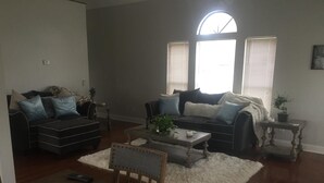 A living room with two sofas, a coffee table, a dining table, and a white furry rug. - right at home in Nashville (Nashville)