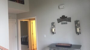 A hallway with a welcome sign, a coat rack, and a framed picture on the wall. - right at home in Nashville (Nashville)