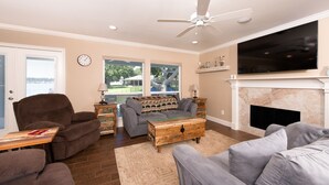 A living room with a fireplace, a television, and a view of the outdoors. - A lakefront getaway (Willis)