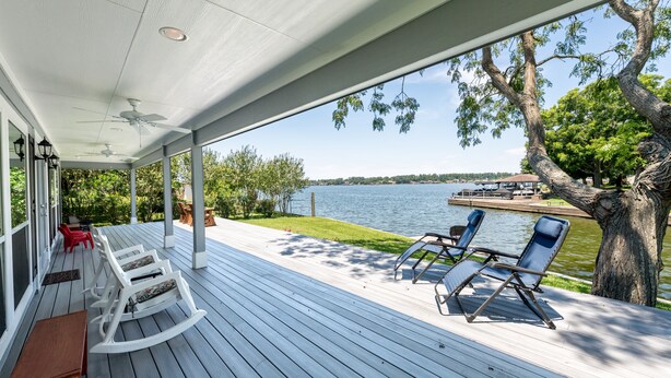 A covered deck with rocking chairs and lounge chairs overlooking a lake. - A lakefront getaway (Willis)