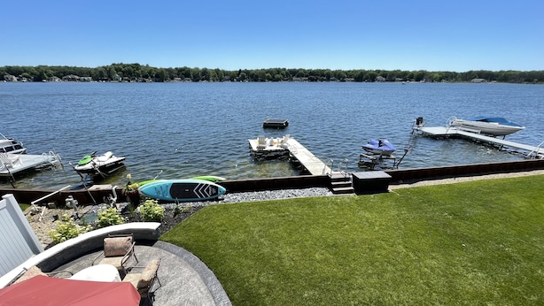 A lakeside dock with boats, a grassy area, and a clear view of the lake. - Eagle Lake Kalamazoo, Mattawan - Lake Livin' (Mattawan)