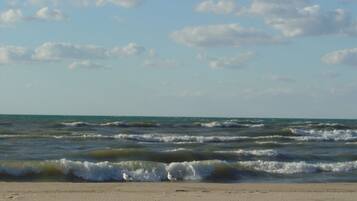 Ein Strand mit Wellen und blauem Himmel.