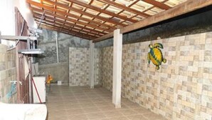 A covered outdoor area with tiled walls and a wooden ceiling.