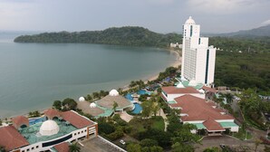 A resort with a beach, a large building with a dome, and a mountain in the background. - 19D Luxury Resort Lifestyle Ocean Views Beachfront (Panama City)