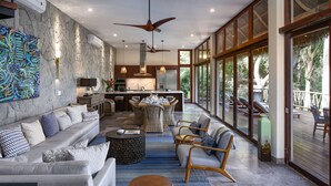 A spacious living area with a sofa, chairs, a dining table, and a kitchen in the background. - Casa Las Hijas,Private Punta Sayulita, Gated Beach Club, 5 min to town, beach (Sayulita)