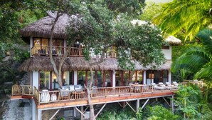 A treehouse with a thatched roof, wooden deck, and outdoor seating area. - Casa Las Hijas,Private Punta Sayulita, Gated Beach Club, 5 min to town, beach (Sayulita)