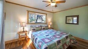 A bedroom with a bed, a ceiling fan, a window, and a nightstand with a lamp. - Magic Escape (Oakhurst CA 93644)