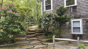 Une maison en bois avec un porche et une clôture en bois.