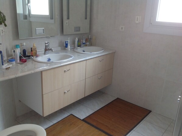 A bathroom with two sinks, a mirror, and a wooden mat on the floor. - Comfortable villa, heated pool in a quiet area, excluding subdivision (Sainte-Anastasie)