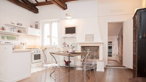 A modern kitchen with a dining table, clear chairs, and a built-in oven.