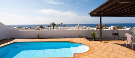 Una piscina climatizada, sombrillas, sillones reclinables de piscina