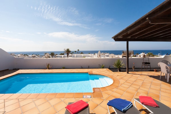 Een verwarmd zwembad, parasols bij het zwembad en ligstoelen