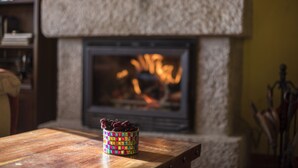 A fireplace with a colorful woven basket on a wooden table in front. - Spa in the house and an unbeatable view of Gredos. (San Juan de Gredos)