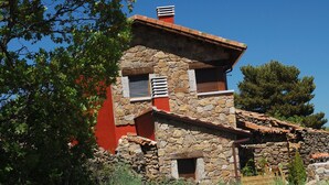 A stone building with a red facade, a chimney, and a small window. - Spa in the house and an unbeatable view of Gredos. (San Juan de Gredos)