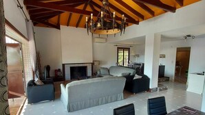 A spacious living area with a fireplace, a dining table, and a large sofa. - Villa with private pool in Torremolinos  (Torremolinos)