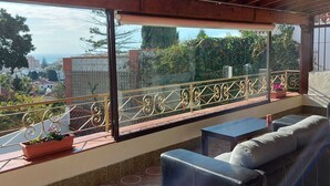 An outdoor patio with a covered seating area, a view of the cityscape, and a decorative railing. - Villa with private pool in Torremolinos  (Torremolinos)