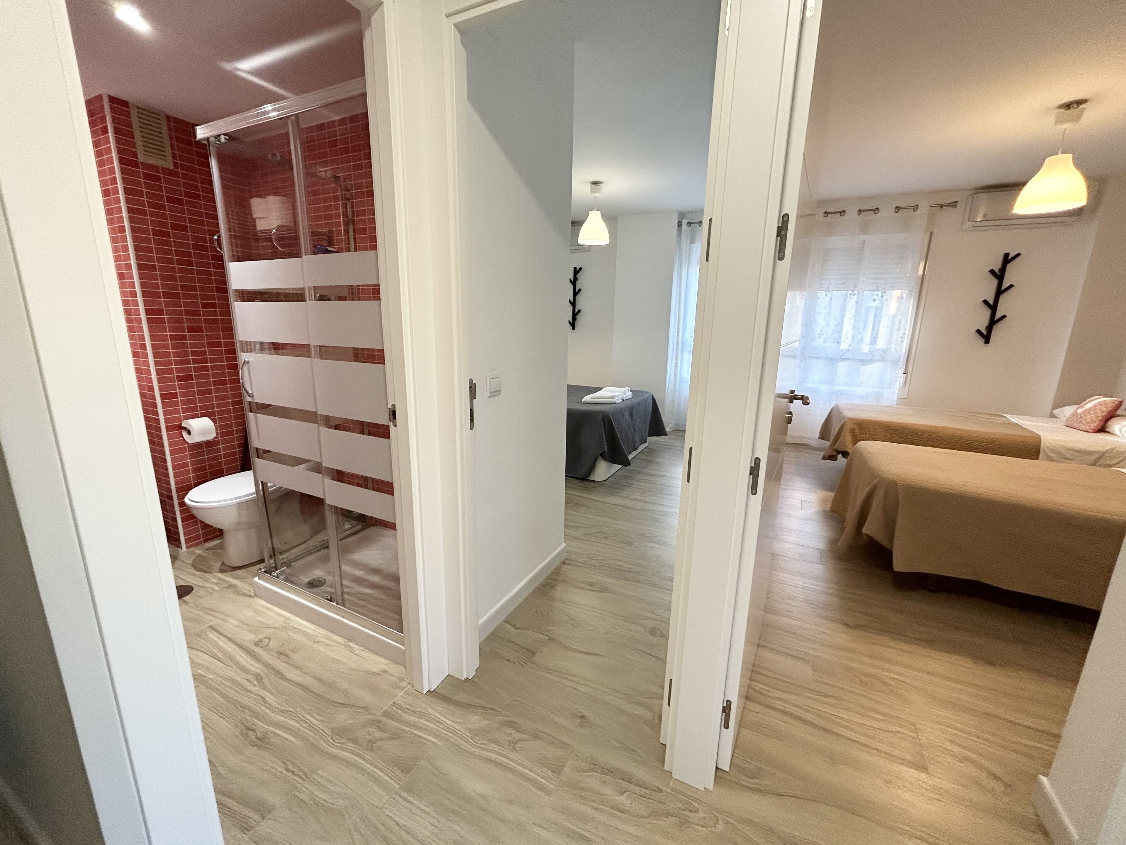 Una camera d'albergo con doccia, un letto, un tavolino e una finestra con tende.