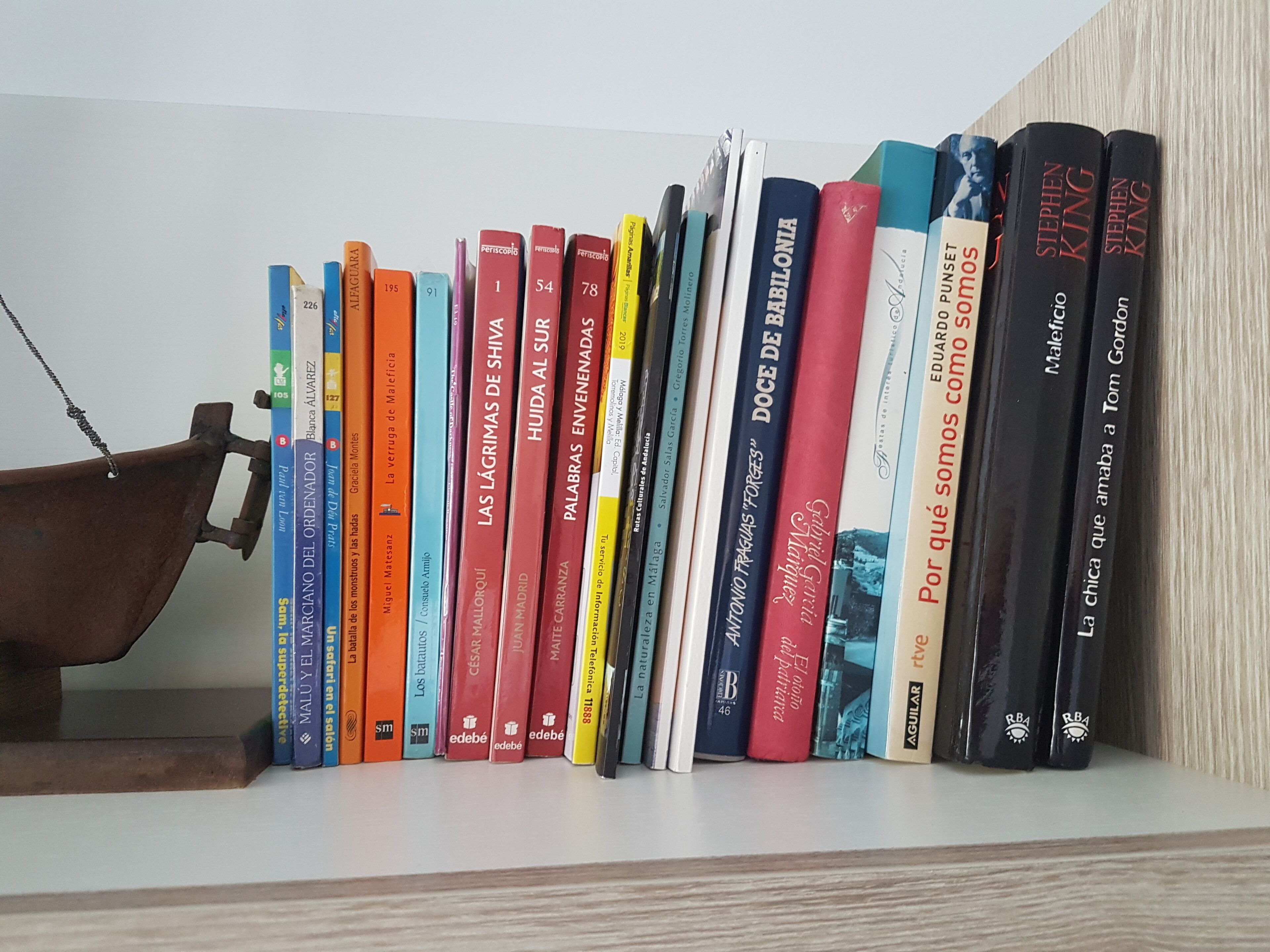 Une bibliothèque remplie d’une variété de livres, dont des titres comme « Las Lagrimas de Shiva » et « Por qué somos como somos ».