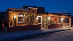 A modern house with a brick exterior, large windows, and a well-lit entrance. - Beautiful house in San Carlos (SAN CARLOS)