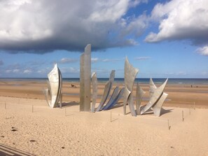 A beach with abstract metal sculptures and a clear sky.