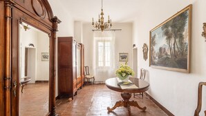 A room with a round wooden table, a chandelier, a large framed painting, and a mirror. - Farmhouse from the 1600s, former home of the Terrerosse Farm. (rimini)