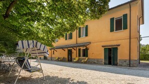 A building with a gravel driveway, outdoor seating, and a covered patio area. - Farmhouse from the 1600s, former home of the Terrerosse Farm. (rimini)
