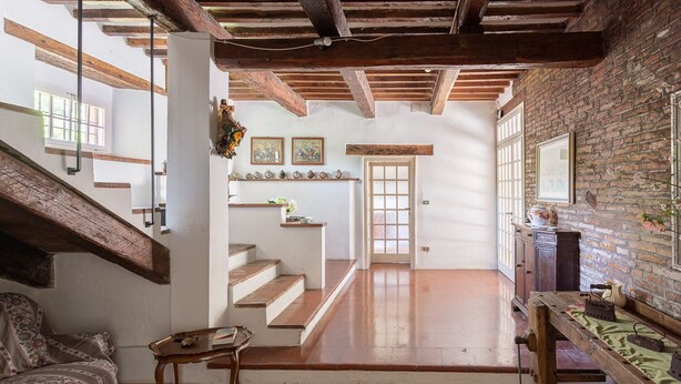 A spacious room with wooden floors, a staircase, and a brick wall. - Farmhouse from the 1600s, former home of the Terrerosse Farm. (rimini)