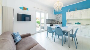 Cocina moderna con comedor, televisor de pantalla plana y balcón.