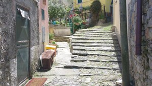 Un escalier étroit en pierre mène à un bâtiment à la façade jaune.
